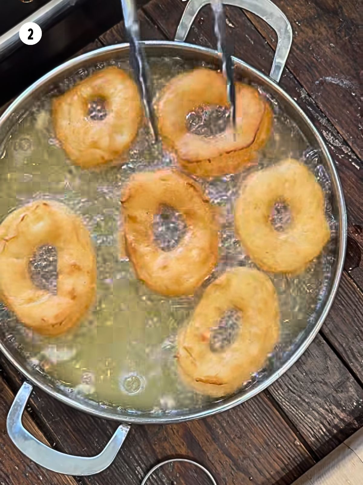 Donuts frying in oil.