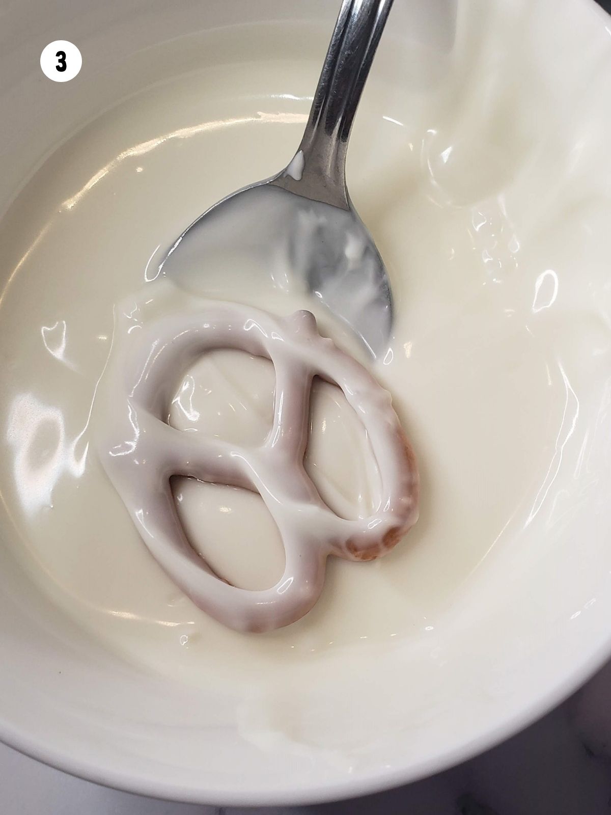 Pretzel flipped over in melted chocolate to coat other side.