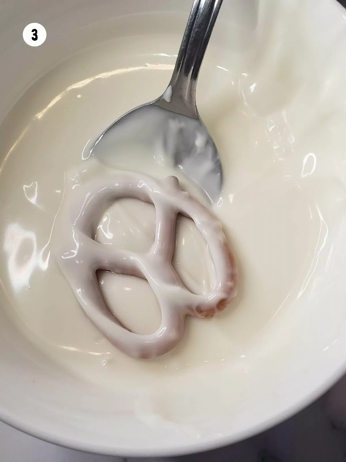 Pretzel flipped over in melted chocolate to coat other side.