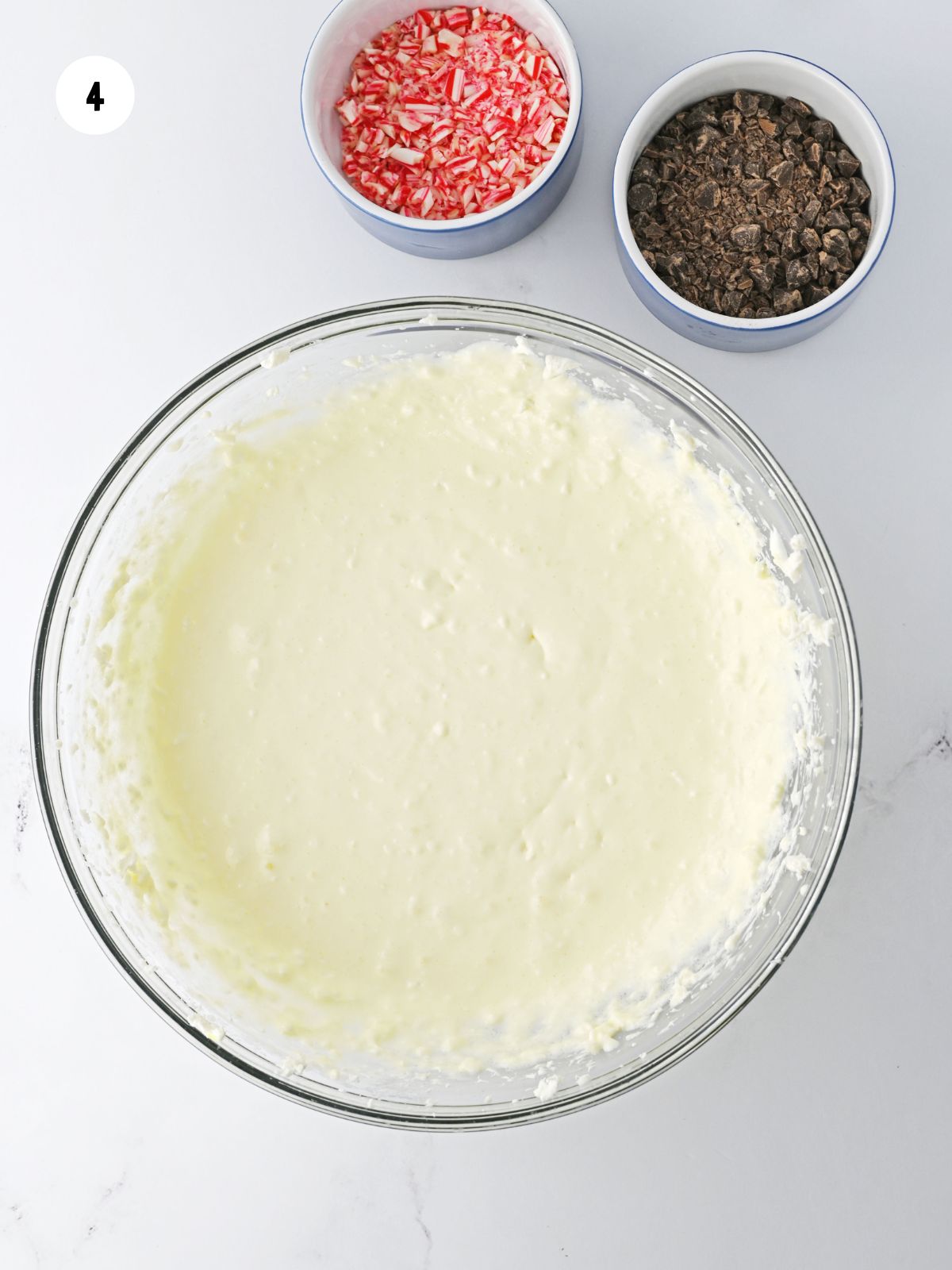 Smooth cheesecake filling in a clear mixing bowl.
