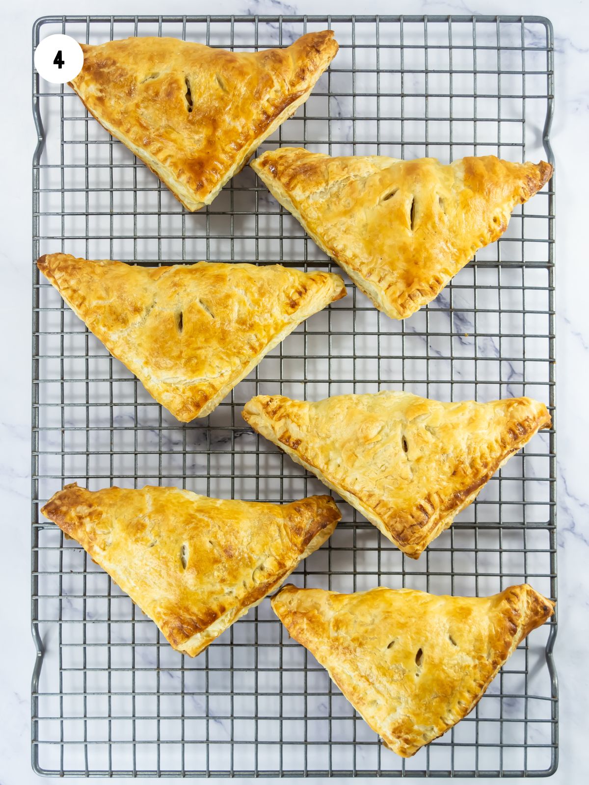 Baked turnovers on a wire cooling rack.