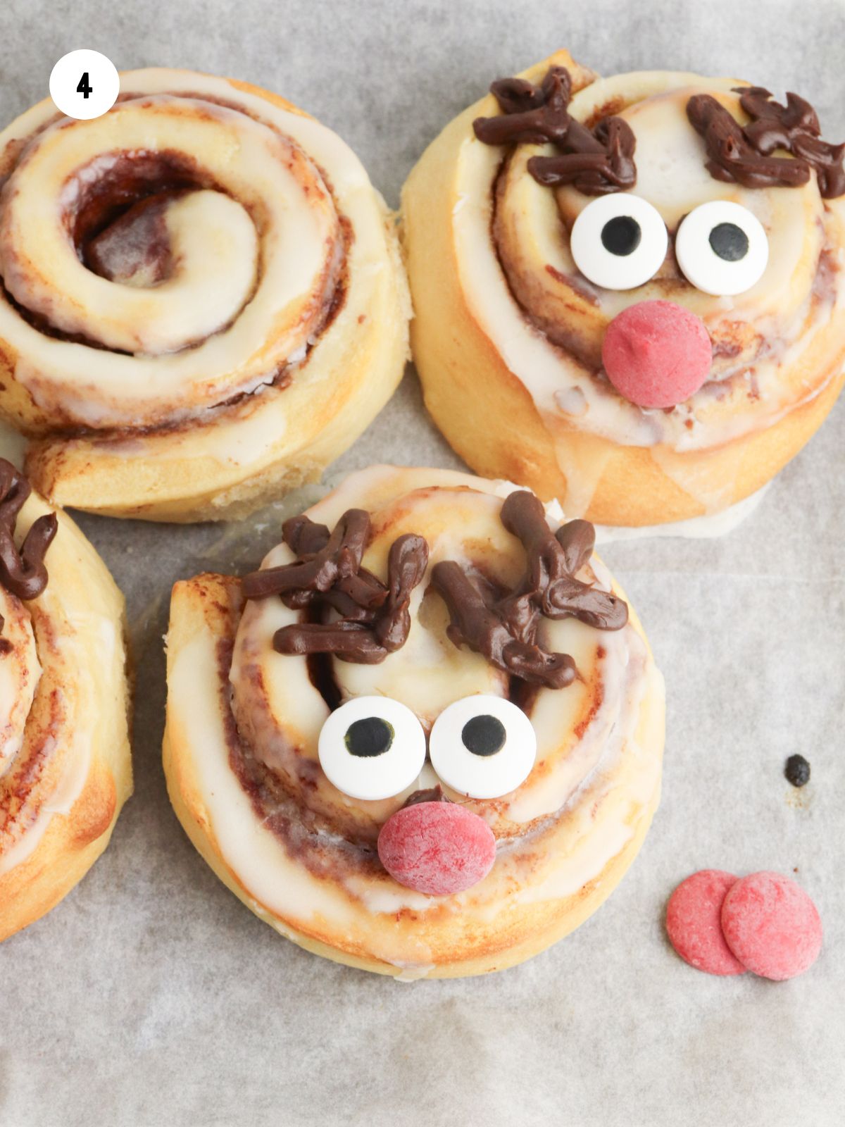 Candy eyes and a red melting wafer added to the cinnamon rolls.