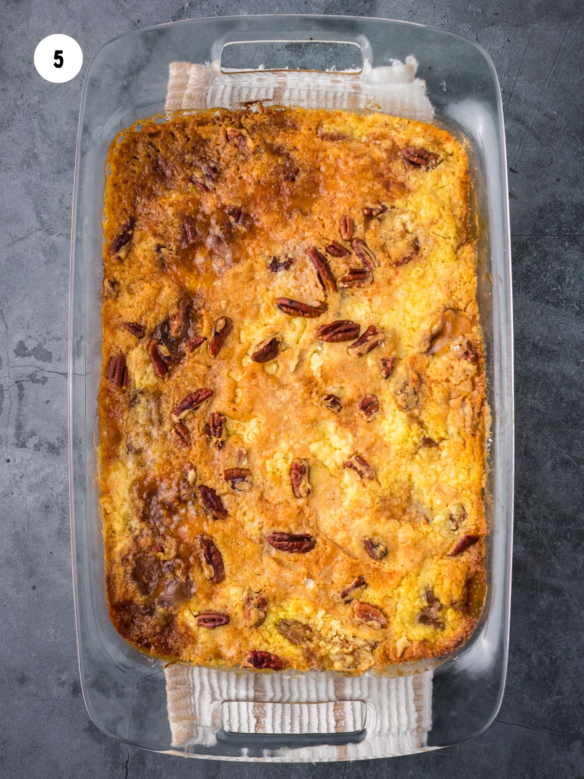 The baked dump cake dish on a striped towel.