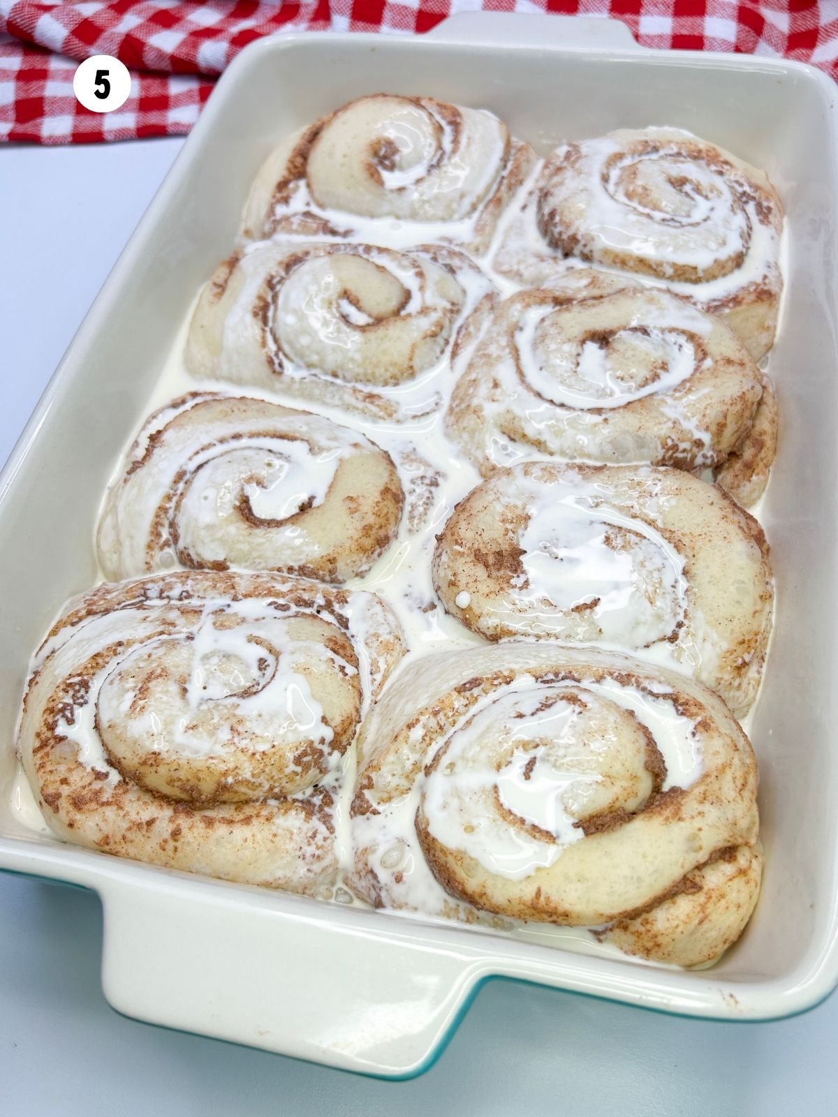 Heavy cream all over the risen rolls.