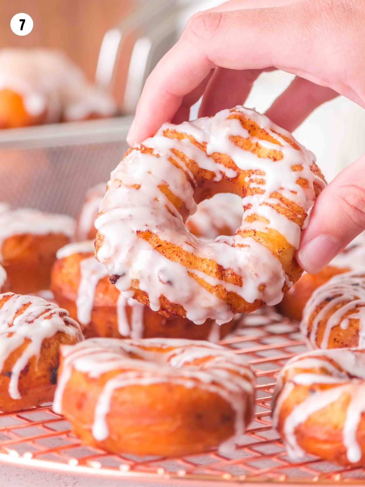 hand holding cinnamon roll donut.