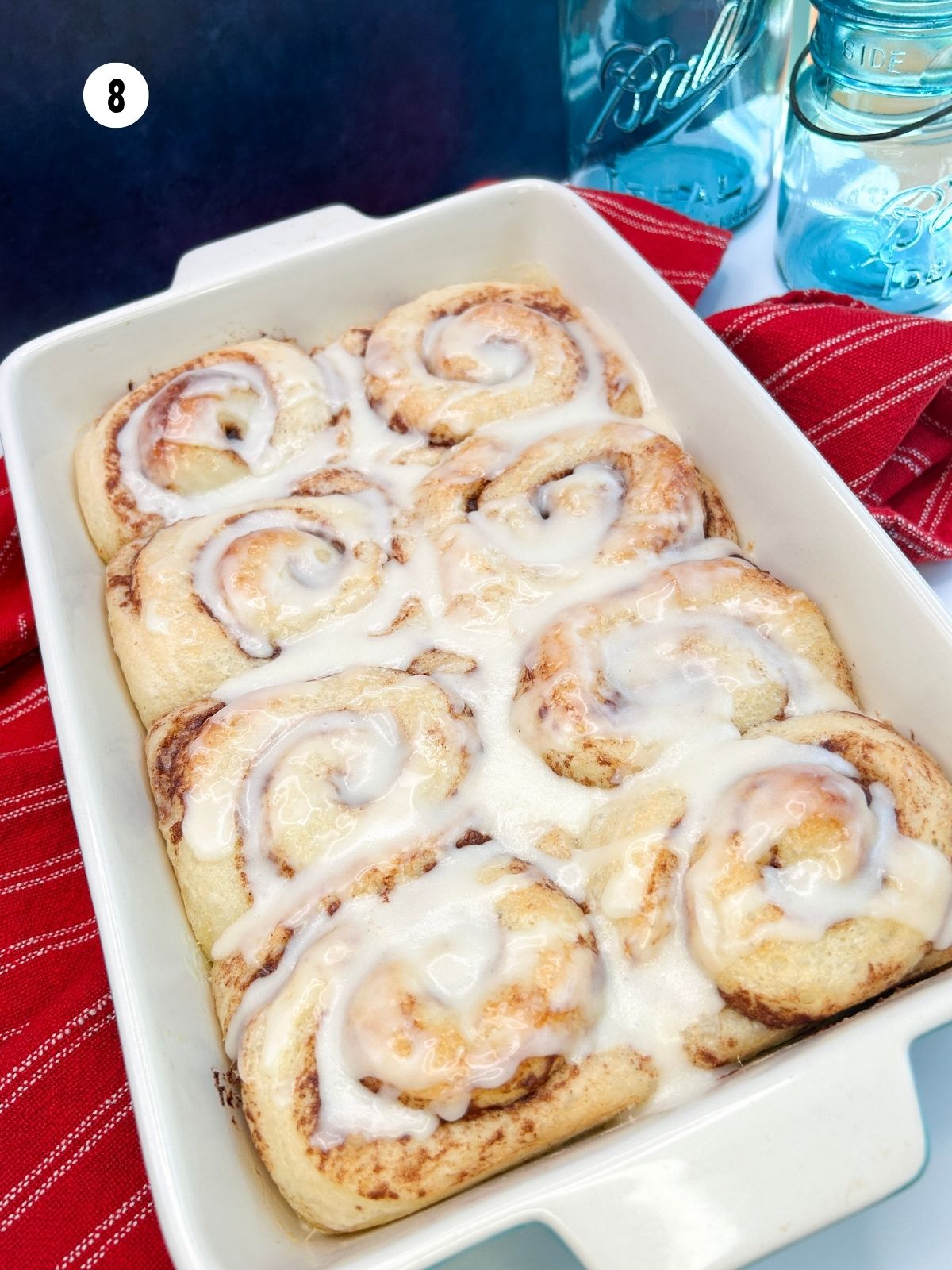 Baked cinnamon rolls frosted with cream cheese frosting.