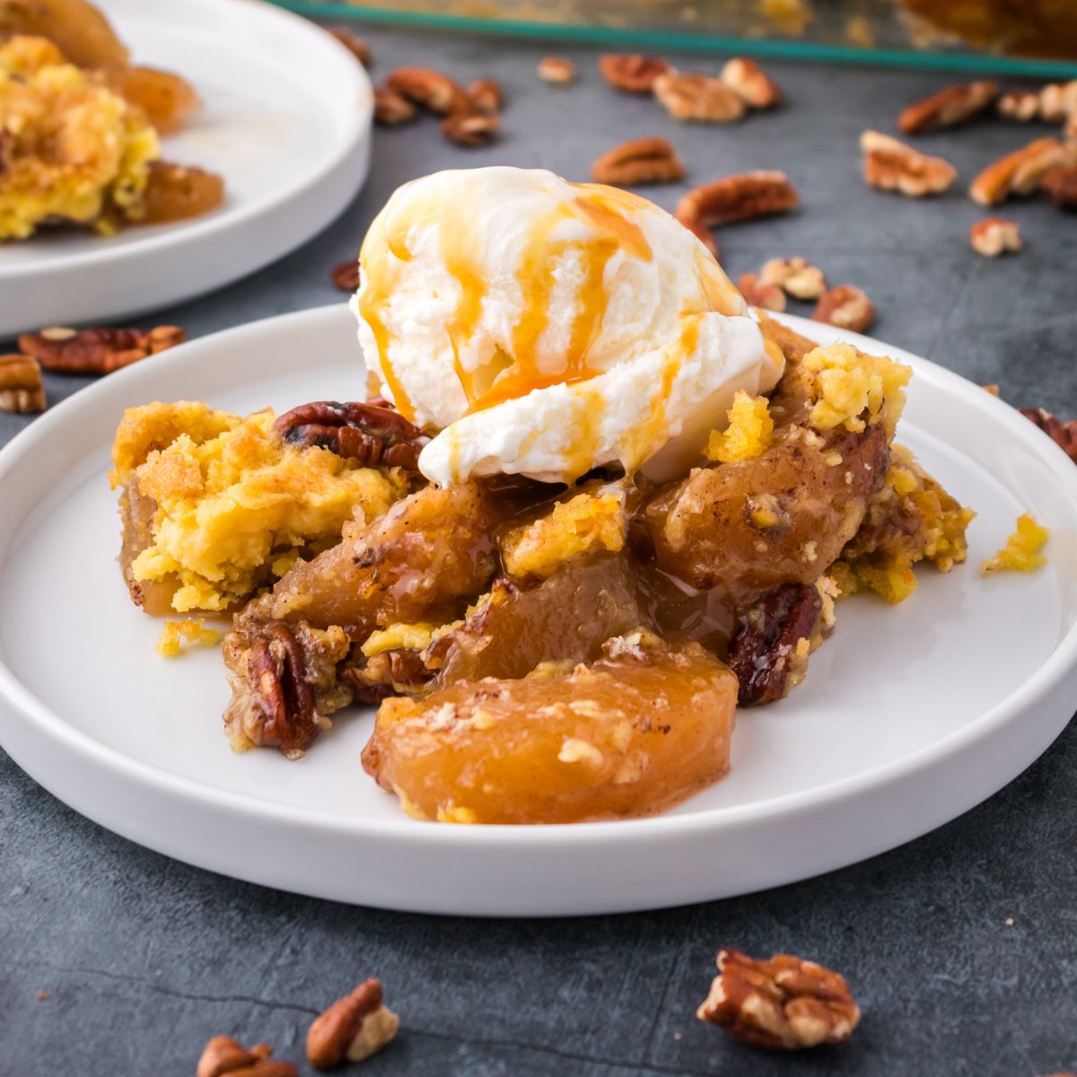 Apple Dump Cake served with a scoop of vanilla ice cream and a drizzle of caramel.