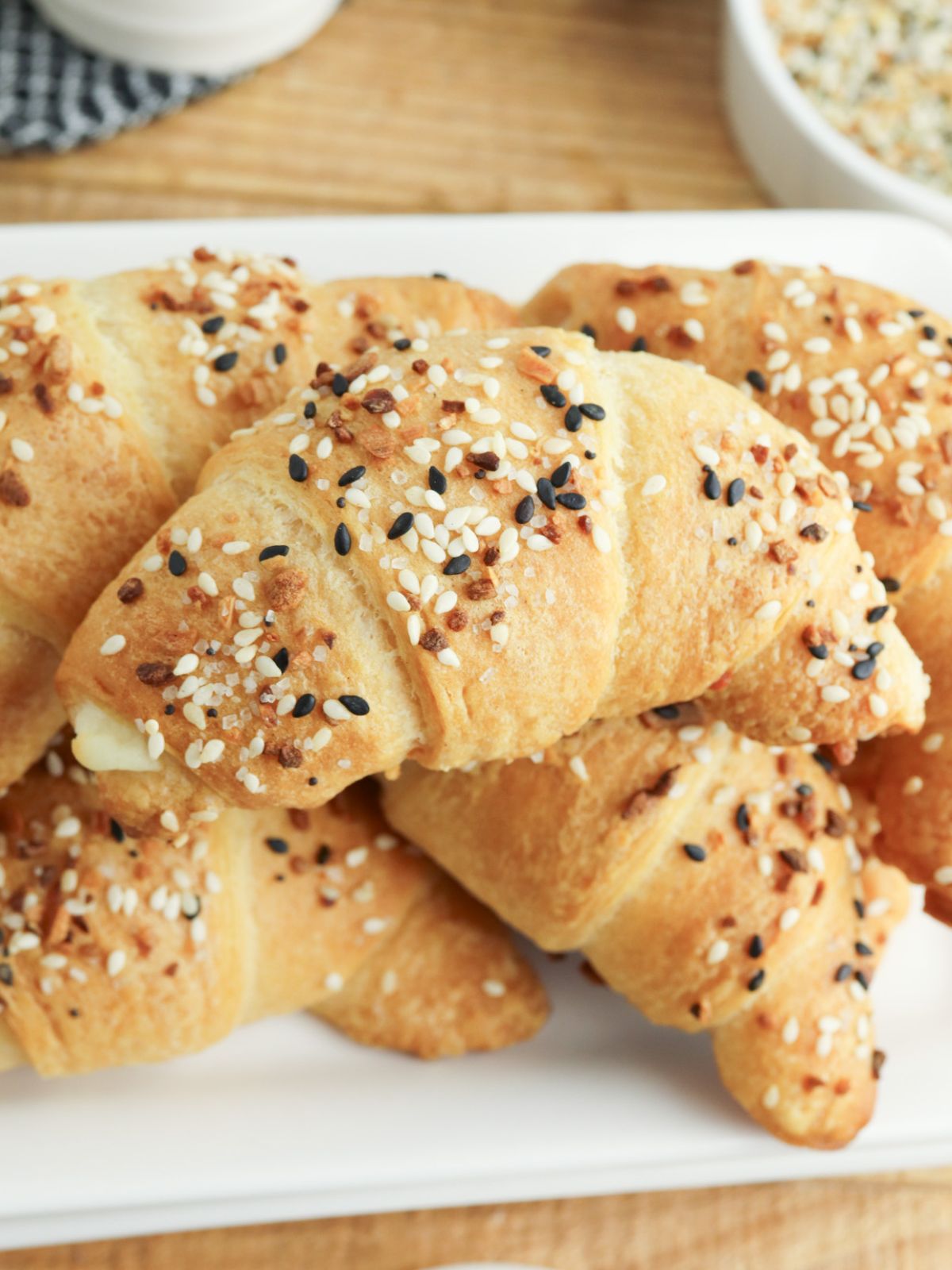 Close up of crescent roll filled with cream cheese and topped with everything bagel seasoning.