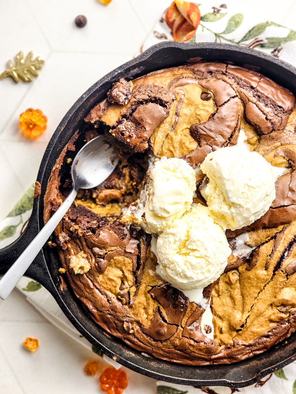 Pumpkin brookie topped with vanilla ice cream and a spoonful of the brownie cookie scooped out.