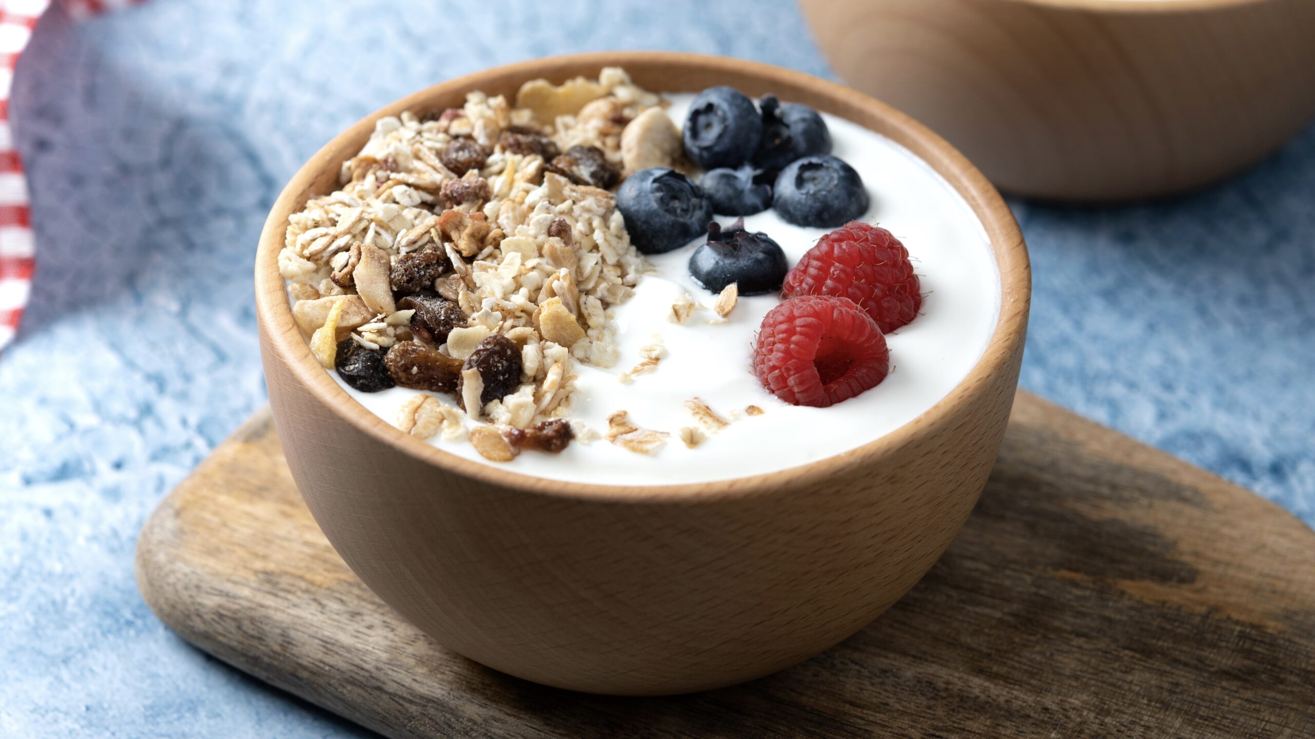 Yogurt with fruit and muesli for breakfast on blue background