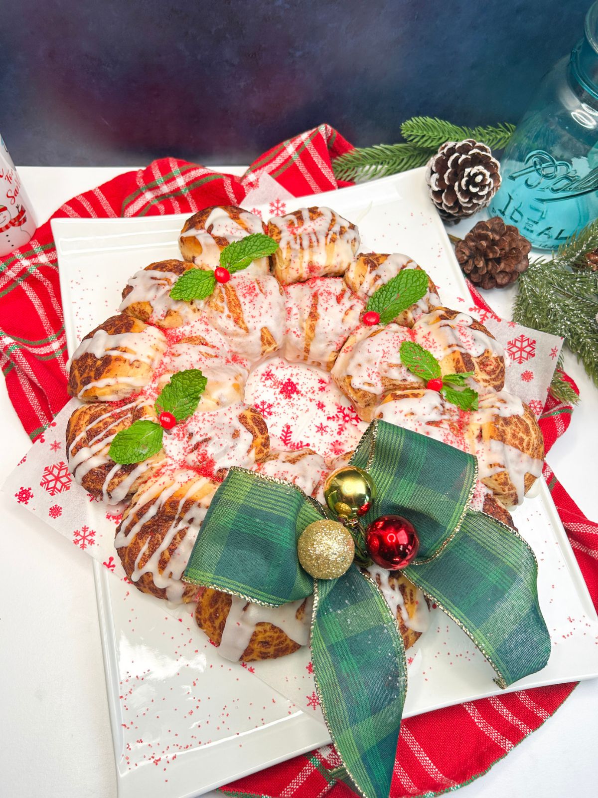 cinnamon rolls shaped into a wreath decorated with festive bow.