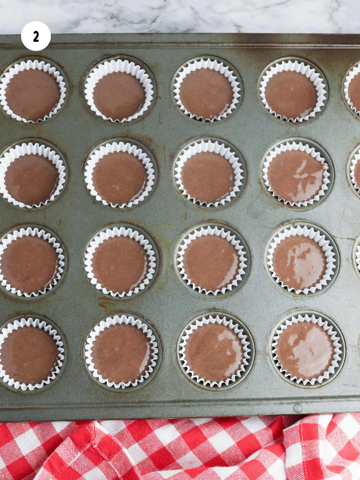 Mini cupcake pan filled with chocolate cake batter.
