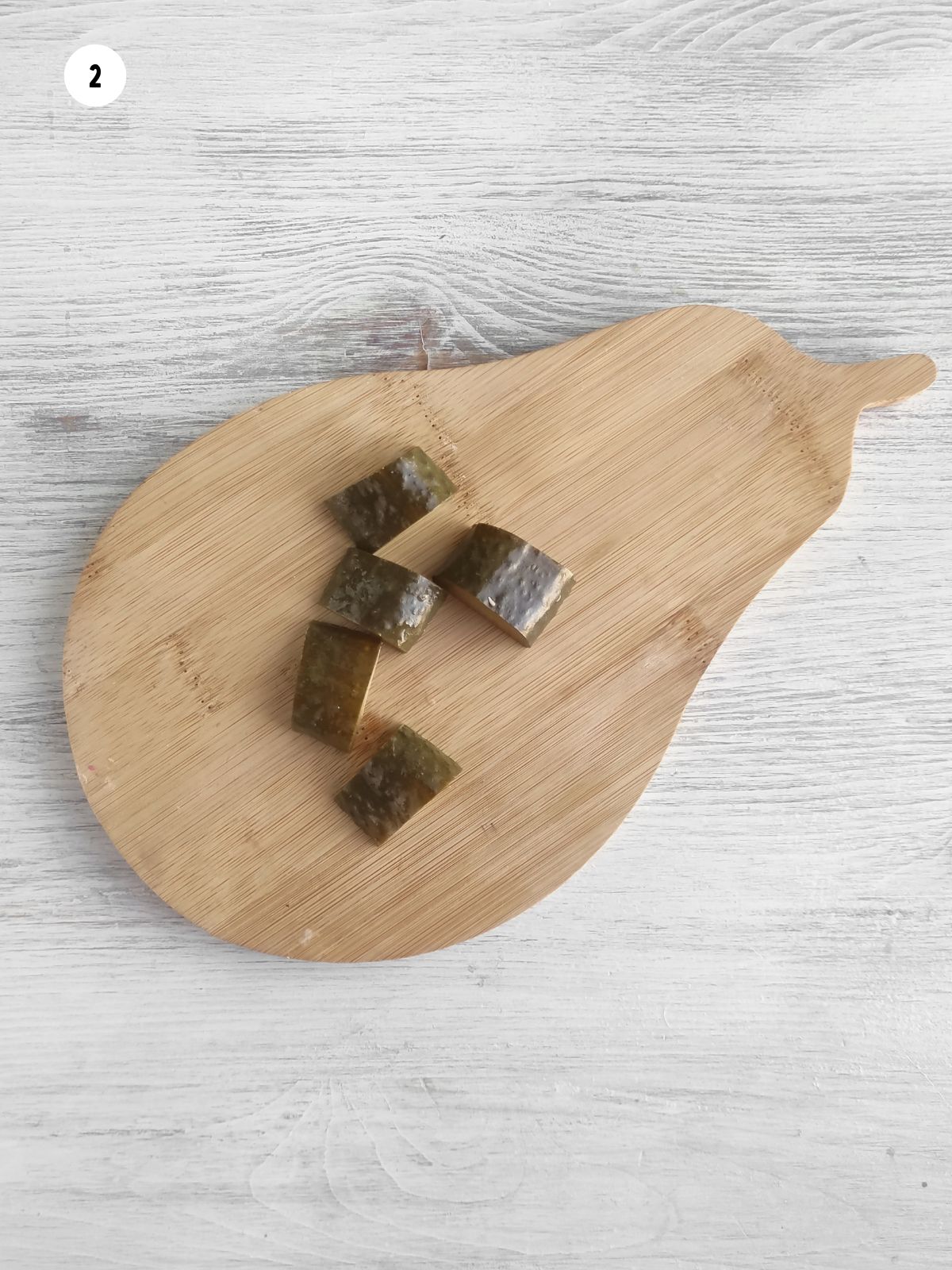 sliced pickles on pear shaped wood cutting board.