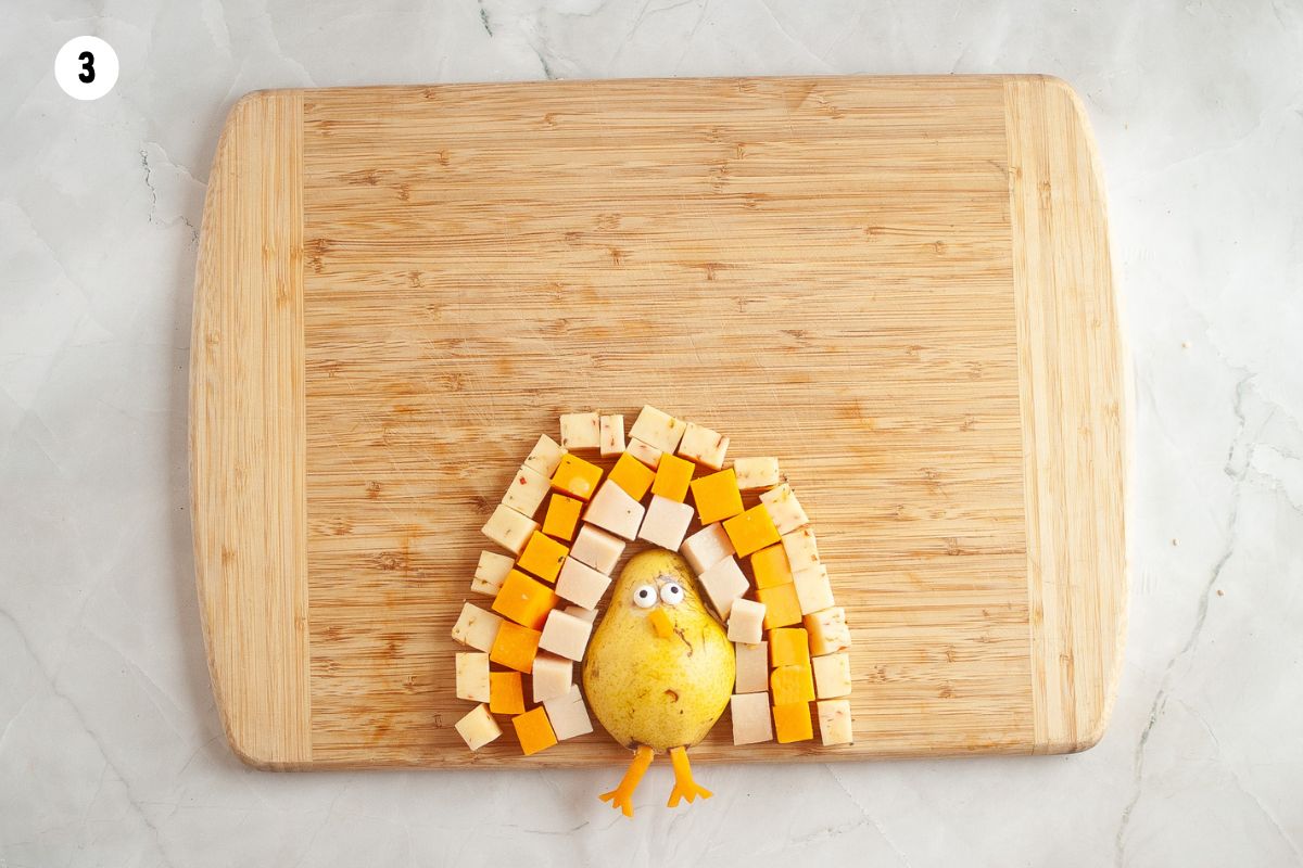 Add layers of cheeses in an arch around the pear.