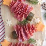 Christmas tree shaped appetizers made out of salami, cheese, and pickle.