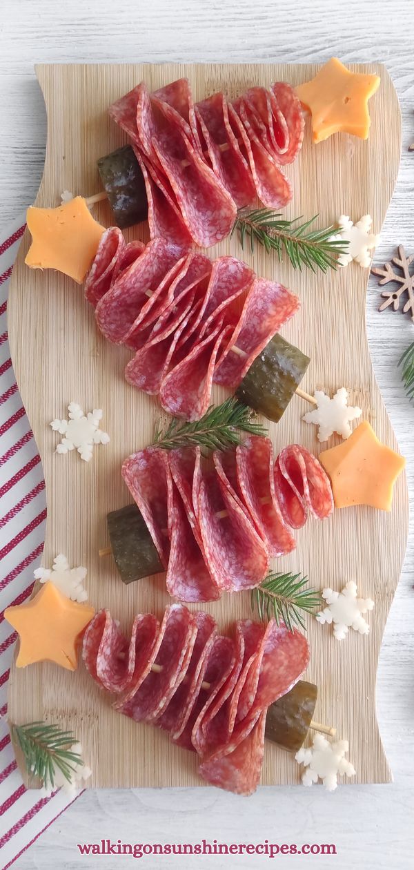 Christmas tree shaped appetizers made out of salami, cheese, and pickle.