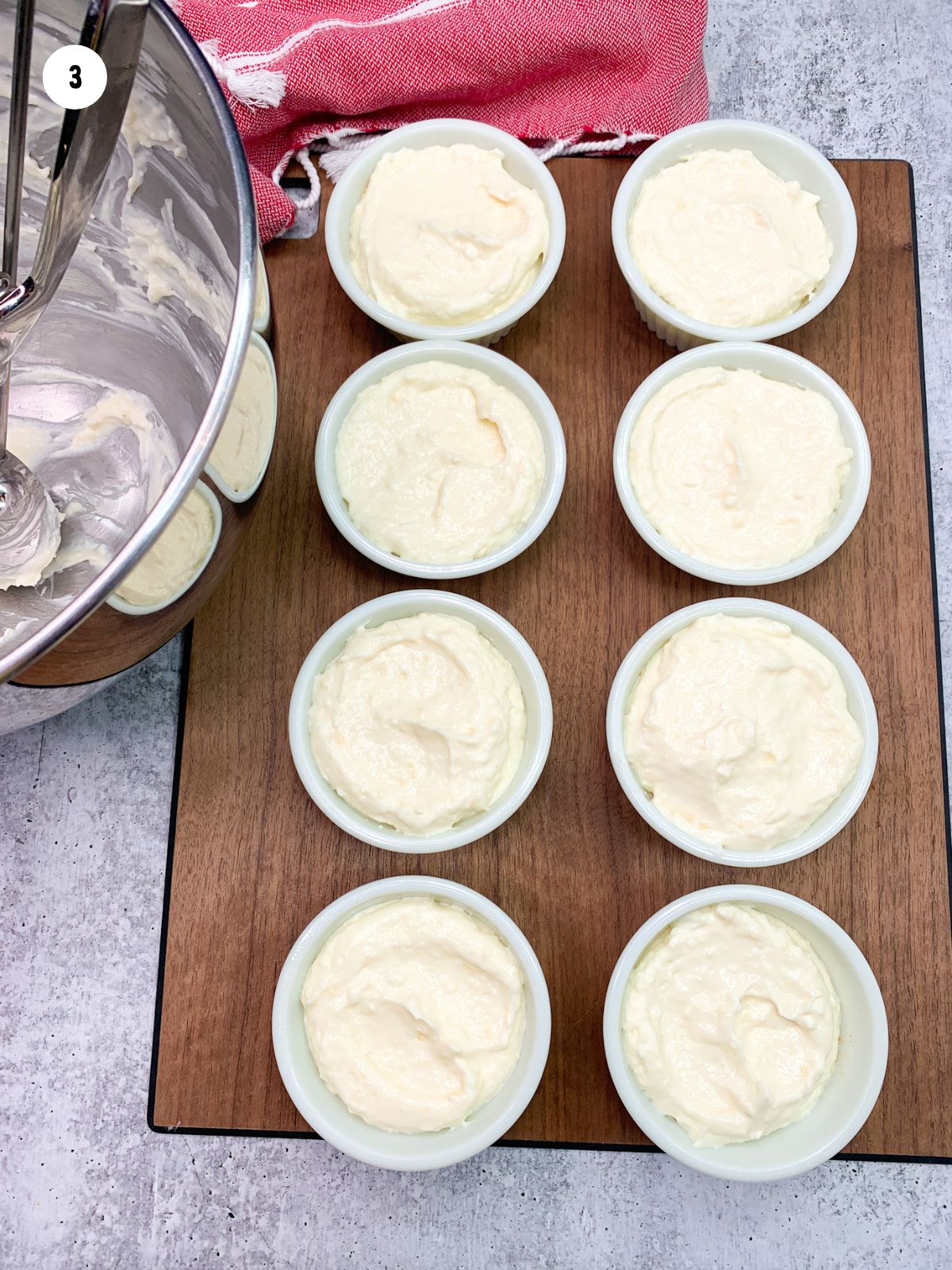 small serving cups of cheesecake pudding on cutting board.