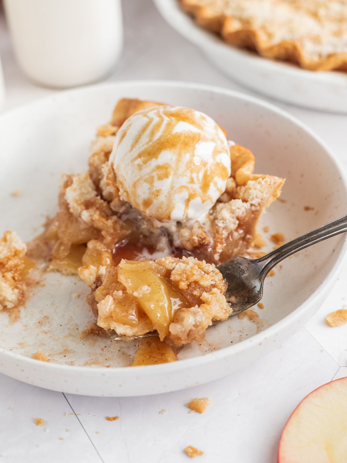 slice of apple pie with crumb topping with fork full.