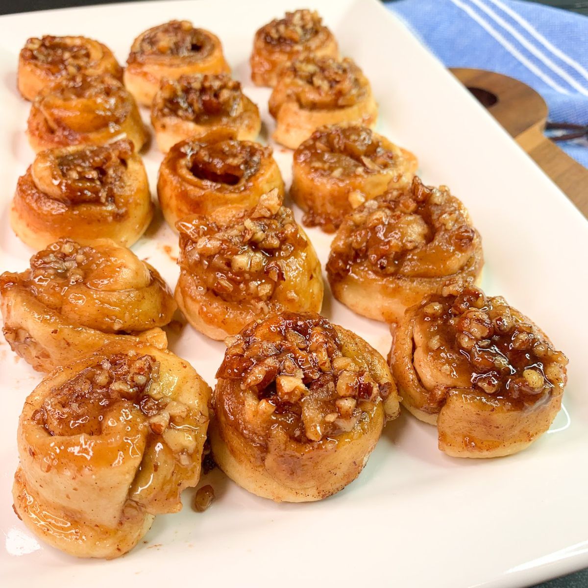 mini pecan rolls on white platter.