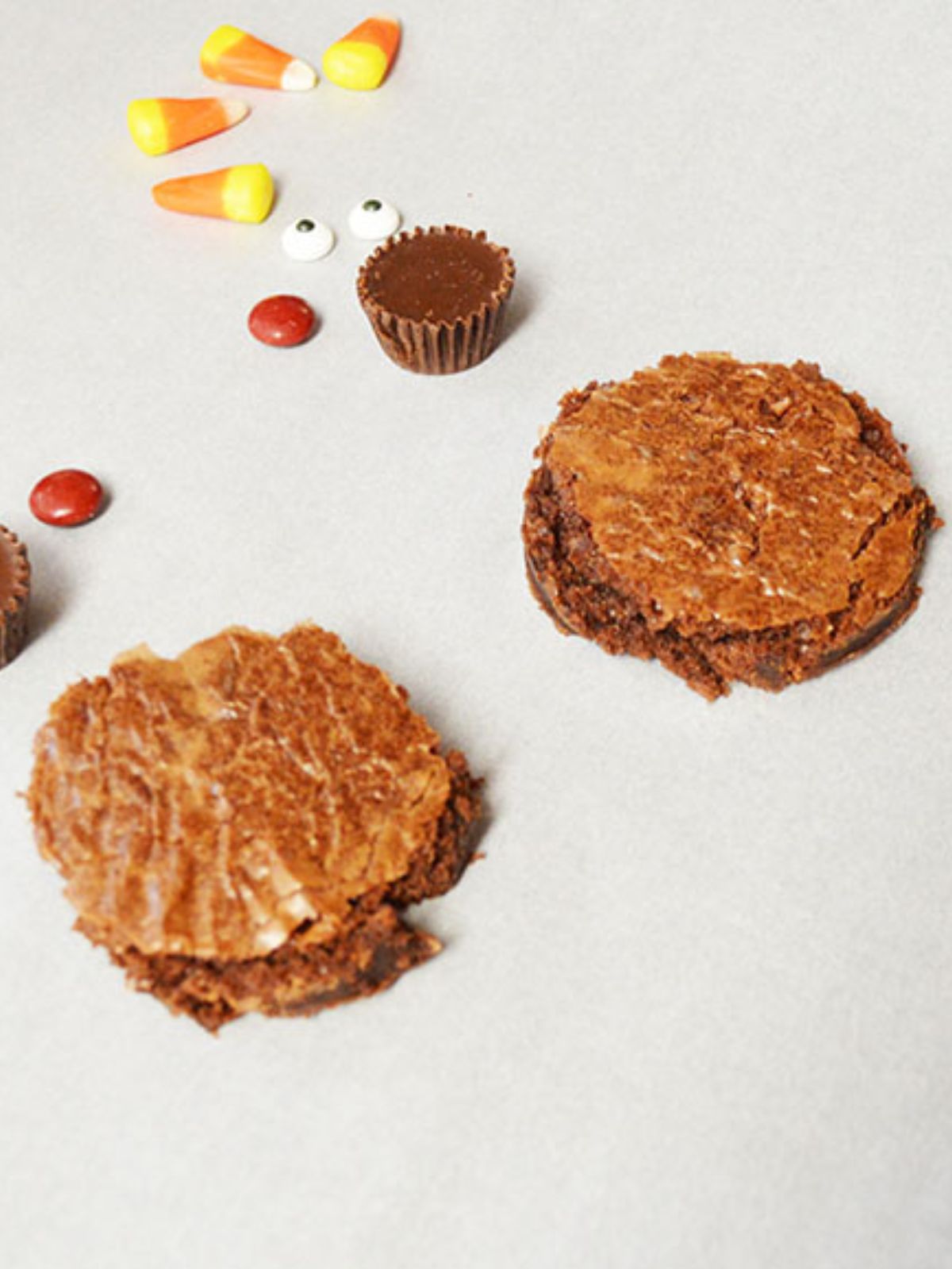 brownies cut into circles with candy corn, candy eyes and peanut butter cups.