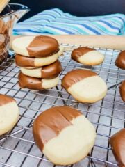 sliced shortbread cookies dipped in melted chocolate on cooling rack.