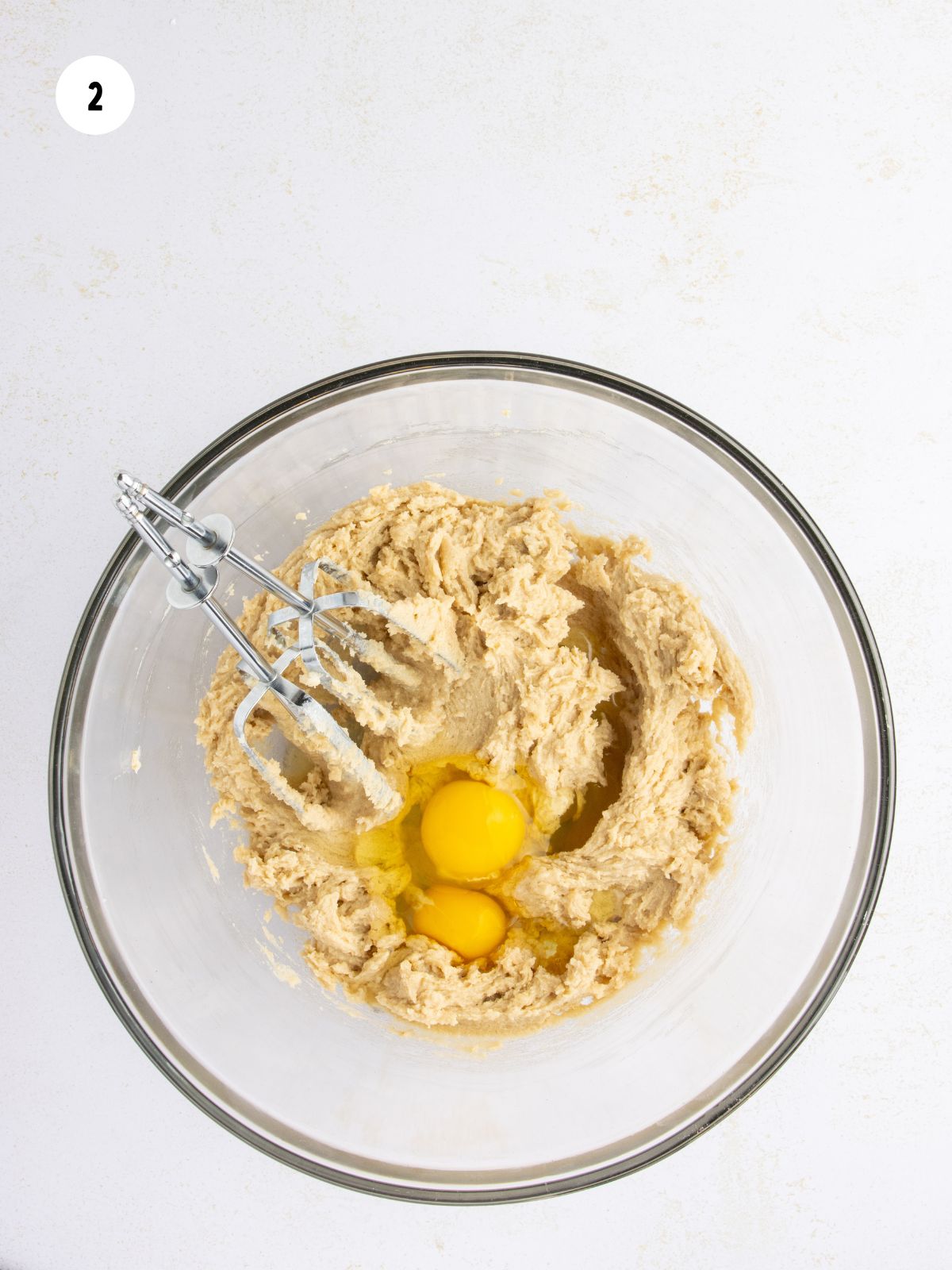 Mixing bowl with eggs added to the cookie batter.