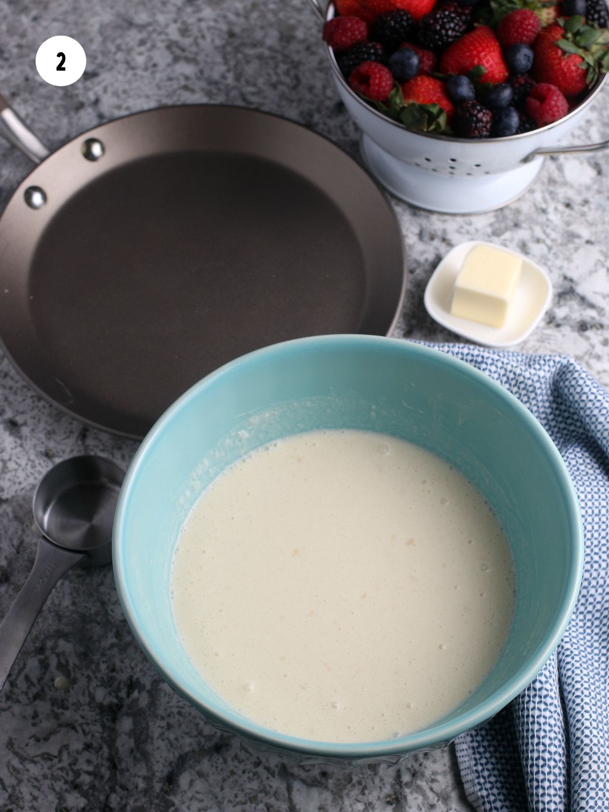 Teal bowl of crepe batter.