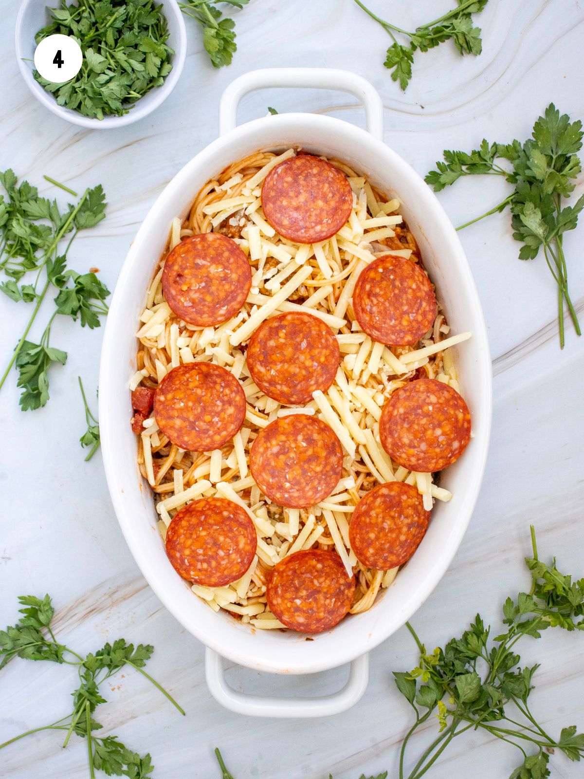 Mozzarella cheese and pepperoni on top of the spaghetti.