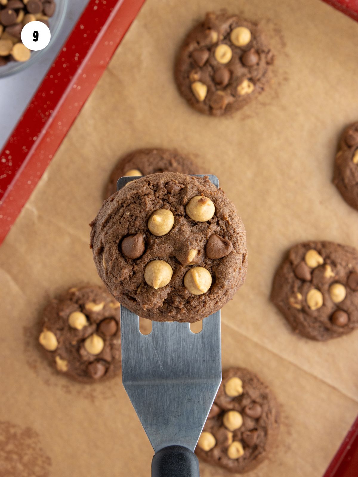 Spatula lifting a baked cookie off the pan.