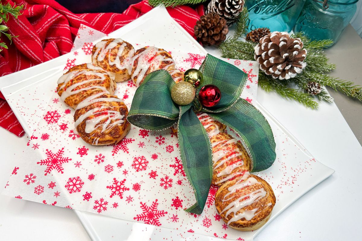 Candy cane danish made with Pillsbury Cinnamon Rolls and decorated with a green Christmas bow.