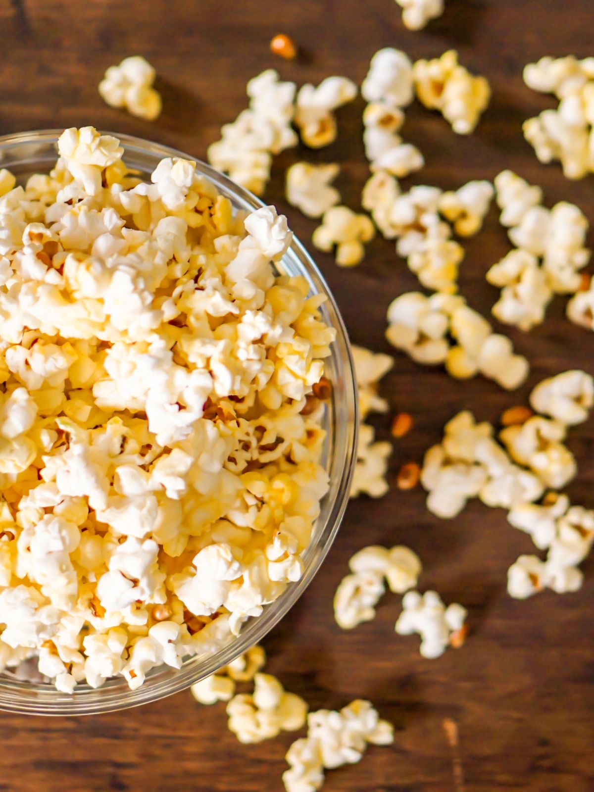 overhead view of a close up of popcorn in clear glass bowl.