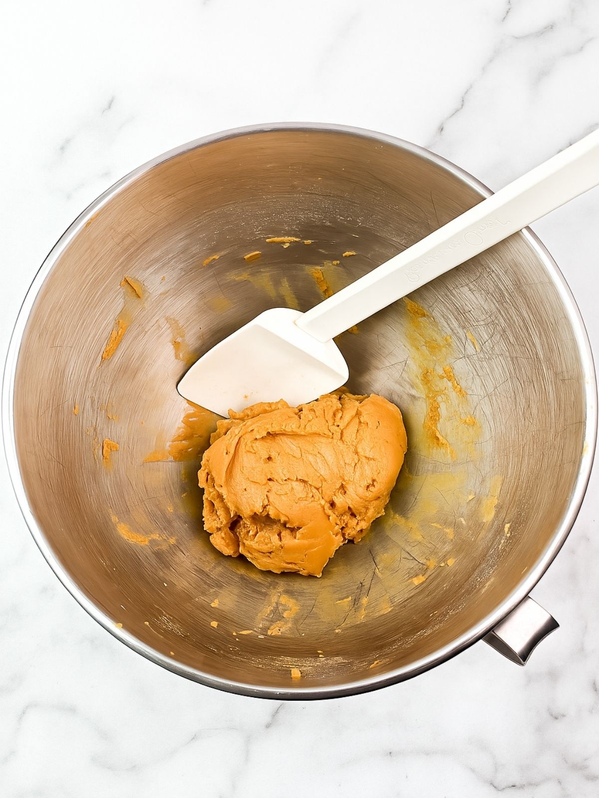bowl of raw peanut butter cookie dough with rubber spatula.