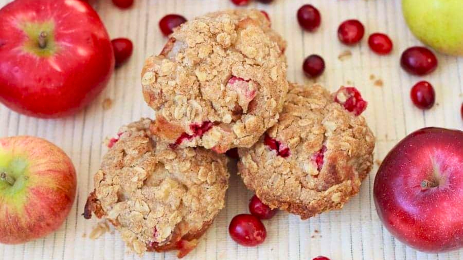 Three apple cranberry muffins with streusel topping.