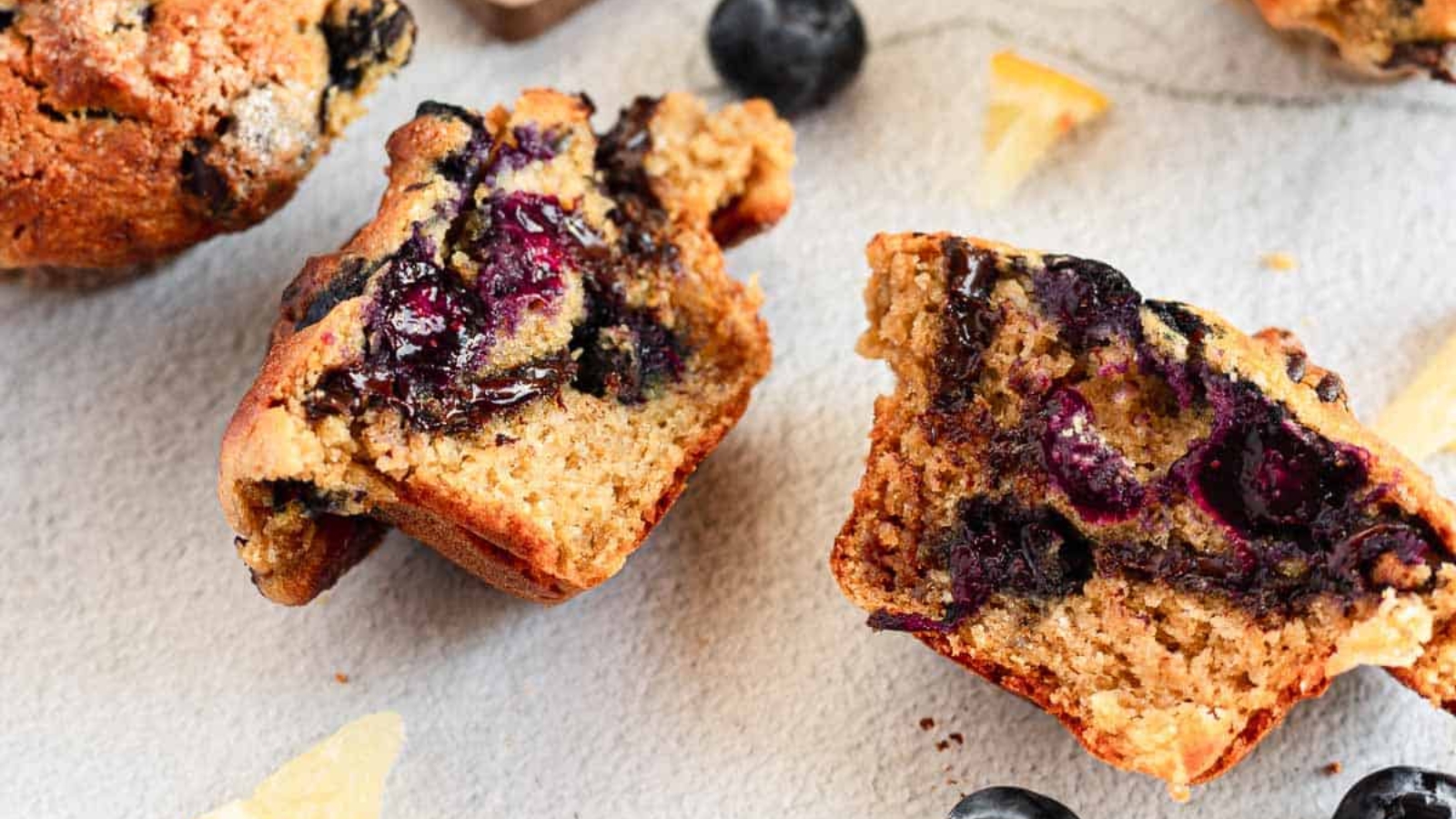 Lemon and blueberry muffin halves with lemon and blueberries.