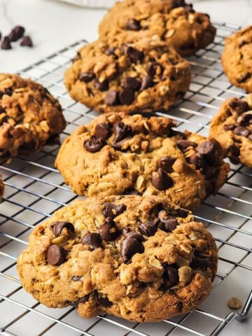 cookies with oatmeal and chocolate chips on cooling rack.