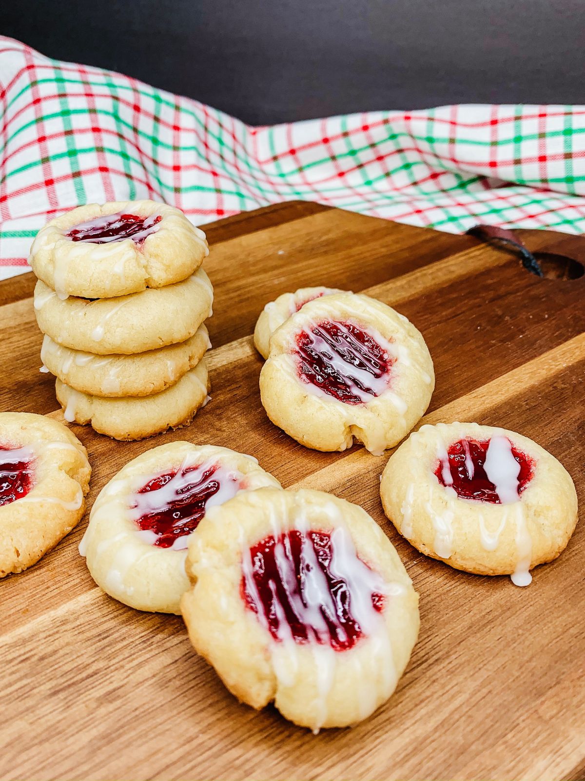 Raspberry Shortbread Thumbprint Cookies - buttery shortbread cookies filled with seedless raspberry jam and a powdered sugar glaze drizzled on top from Walking on Sunshine Recipes. Raspberry Shortbread Thumbprint Cookies for Christmas.