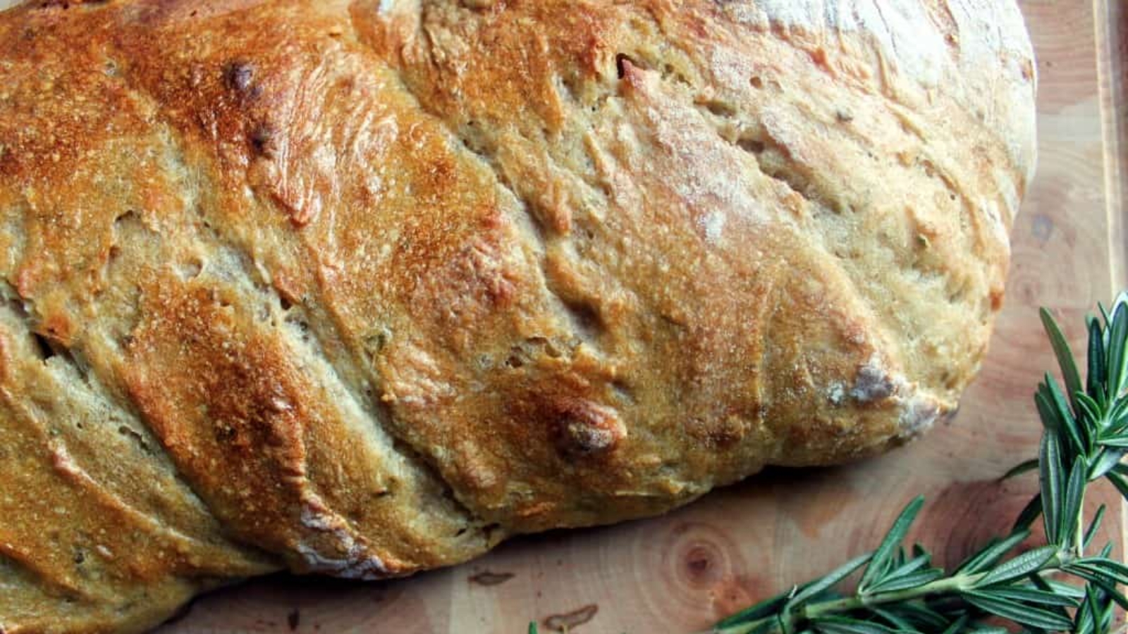 Rosemary sourdough bread on cutting board.