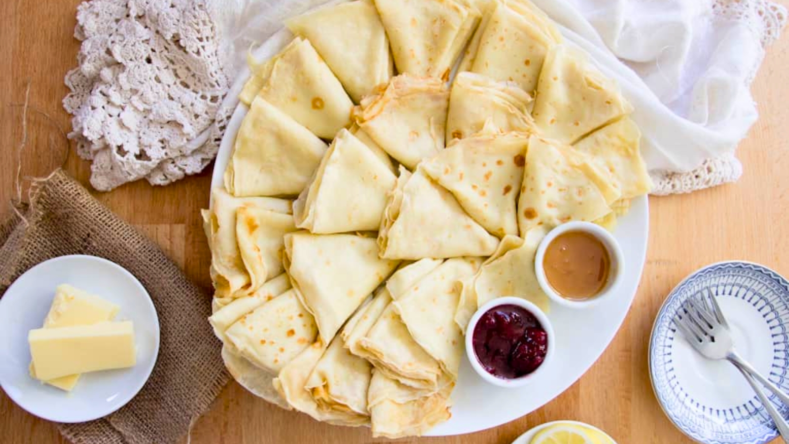 A plate of crepes with jam and sauce on it.