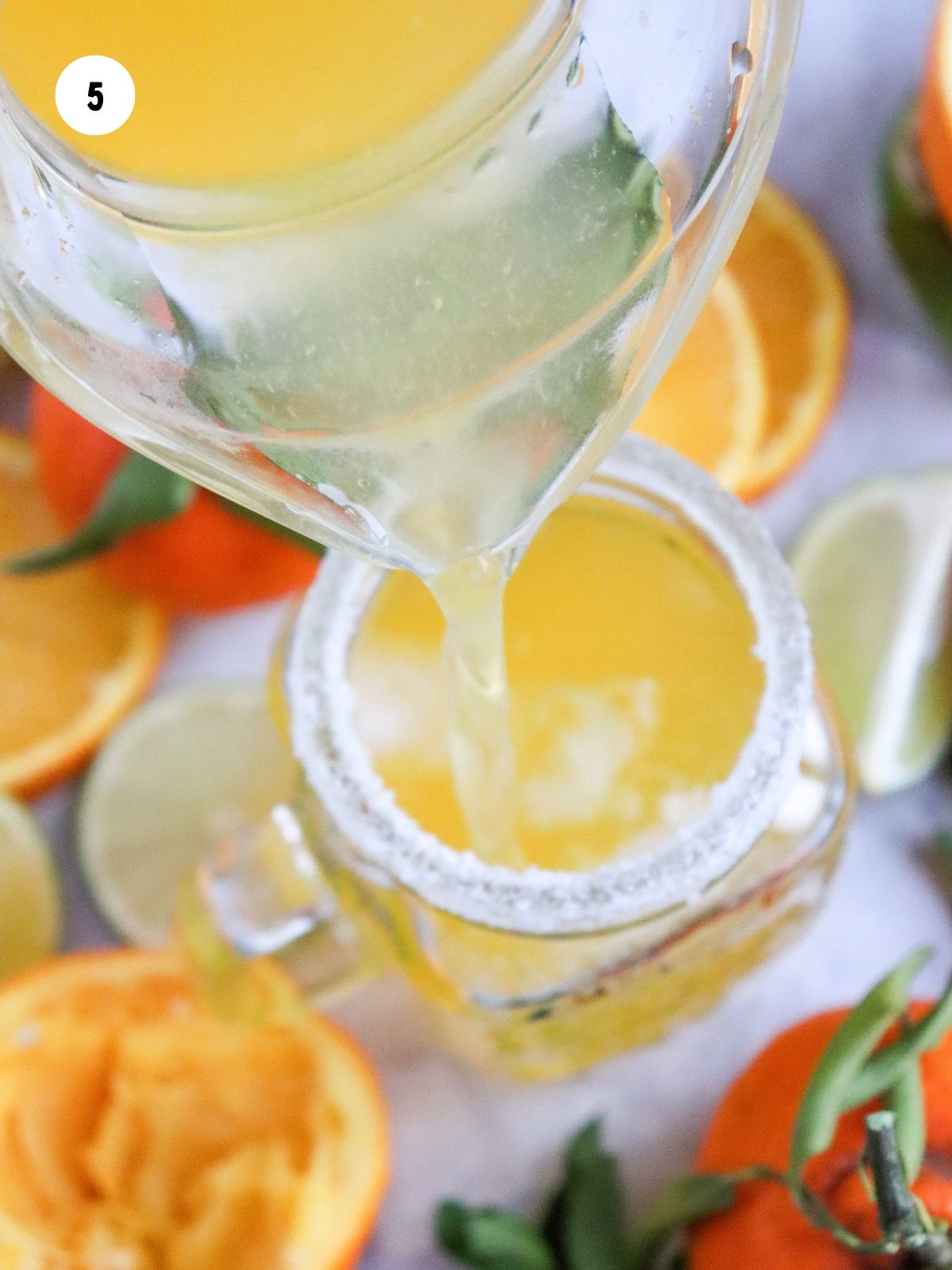 Mocktail being poured into a salt rimmed glass.