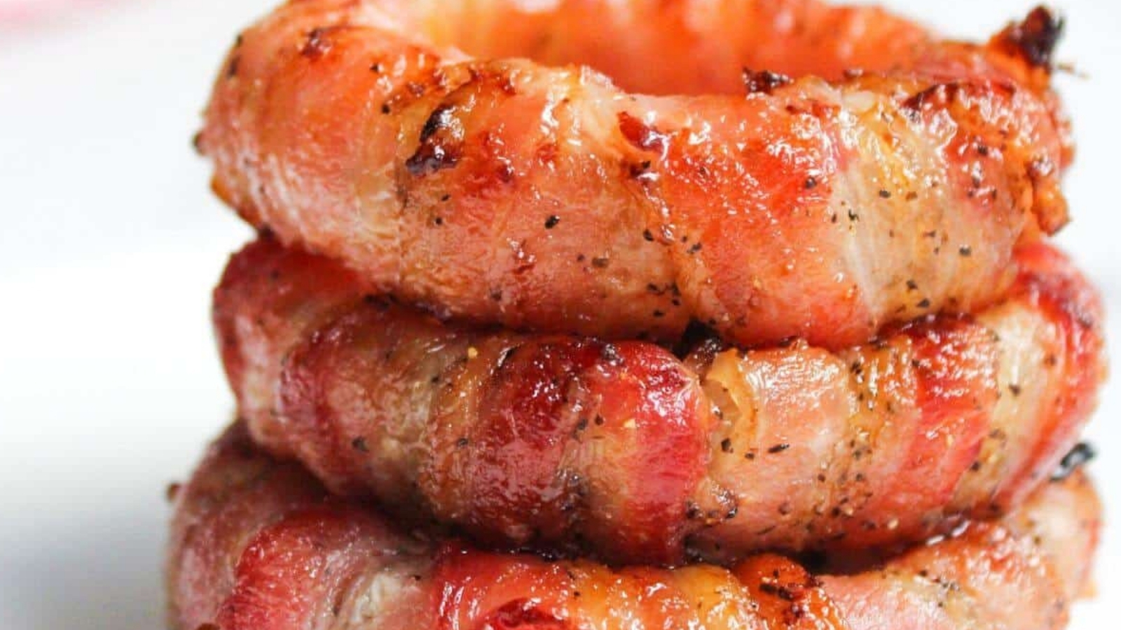Stack of bacon wrapped onion rings.