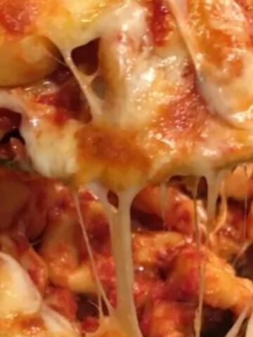 Cheesy baked tortellini casserole with melted cheese on top.