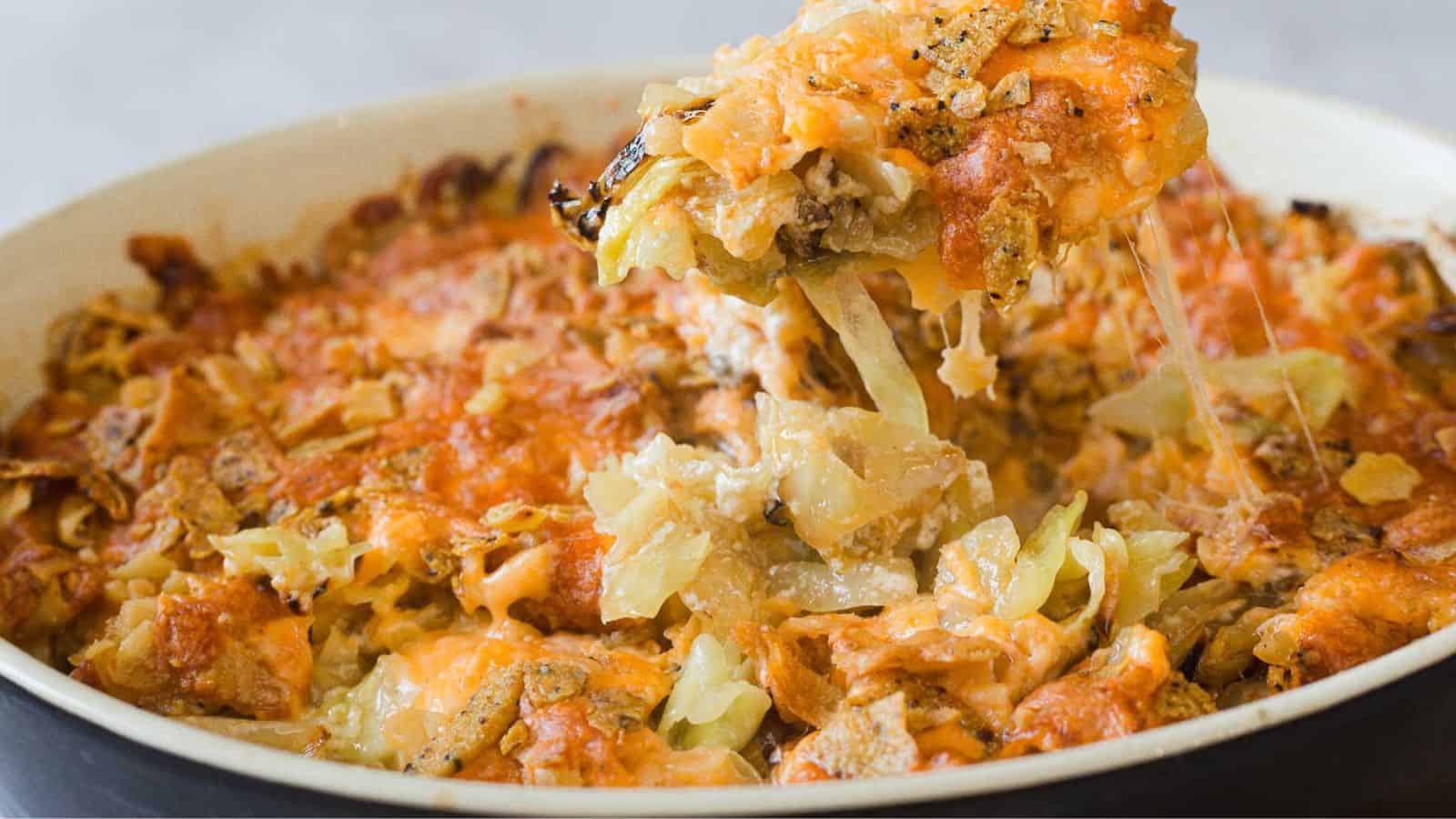 A casserole dish filled with a cheesy cabbage casserole.