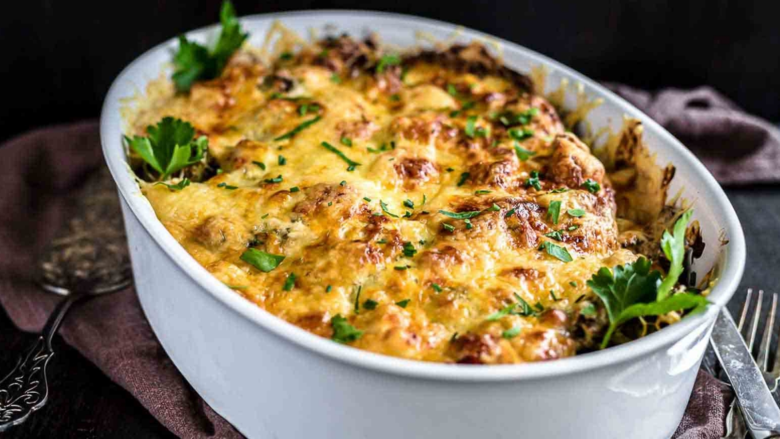 Chicken casserole with baked cheese inside a white dish.
