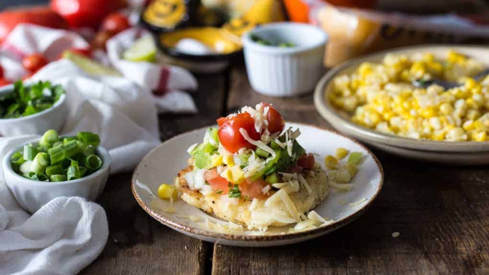 Cheese arepa on a plate with toppings.