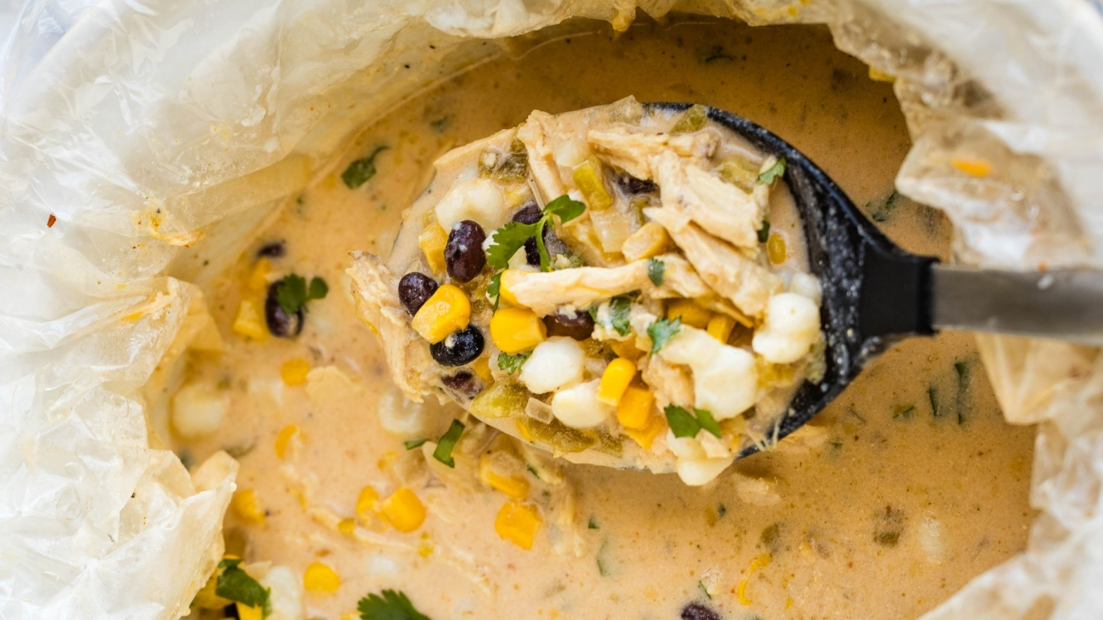 A bowl of mexican chicken chowder with corn and black beans.
