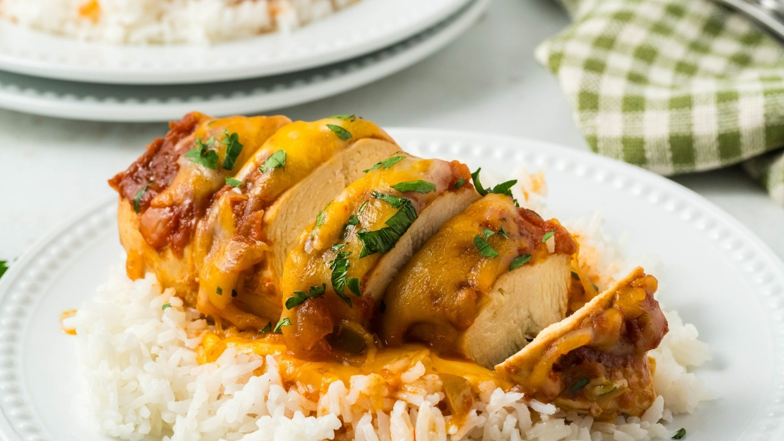Crockpot Cheesy Salsa Chicken on a plate with rice and sauce.