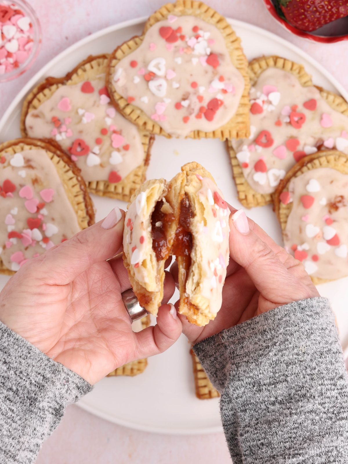 Inside of a strawberry hand pie showing the jam filling and flaky crust.