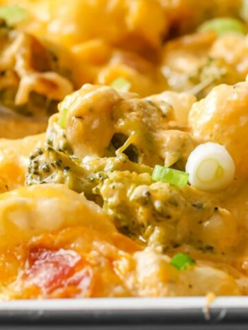 Loaded broccoli cauliflower casserole in a baking dish garnished with green onions.