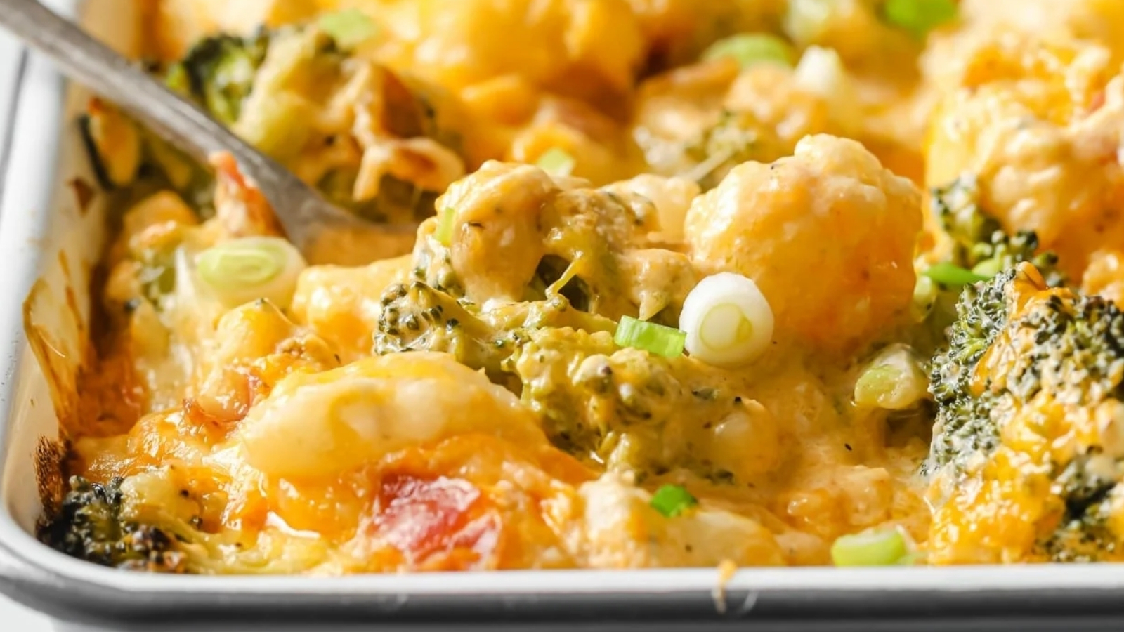Loaded broccoli cauliflower casserole in a baking dish garnished with green onions.