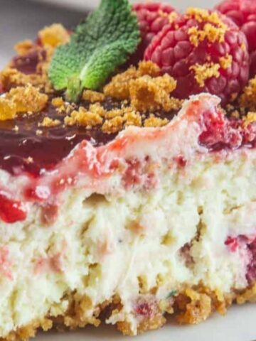 Raspberry ricotta cheesecake with a creamy white filling topped with scattered fresh raspberries.